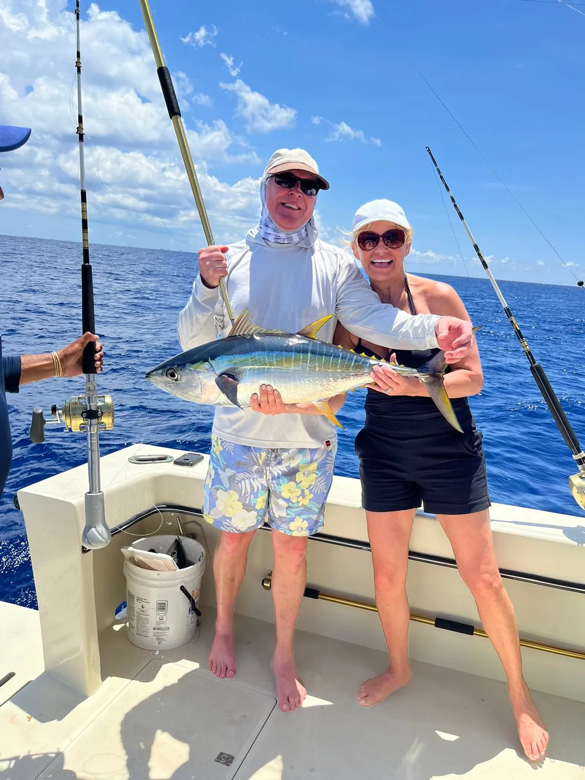 Two guests holding up a tuna on a fishing charter