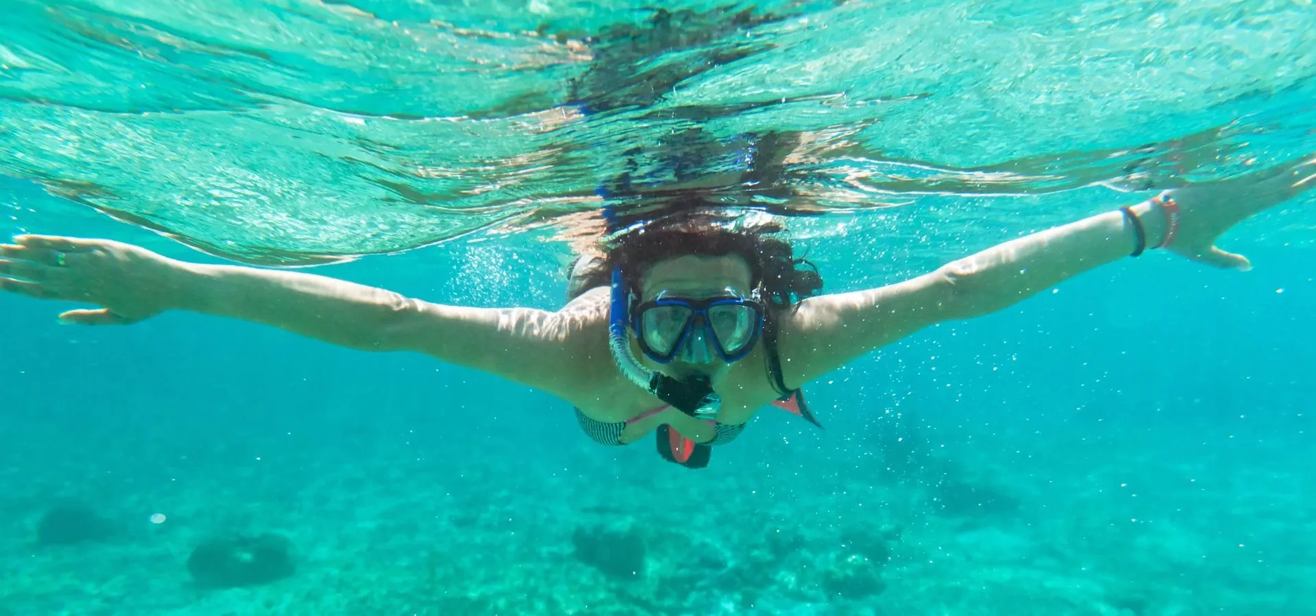 A guest snorkeling in clear spring water on a manatee swim tour