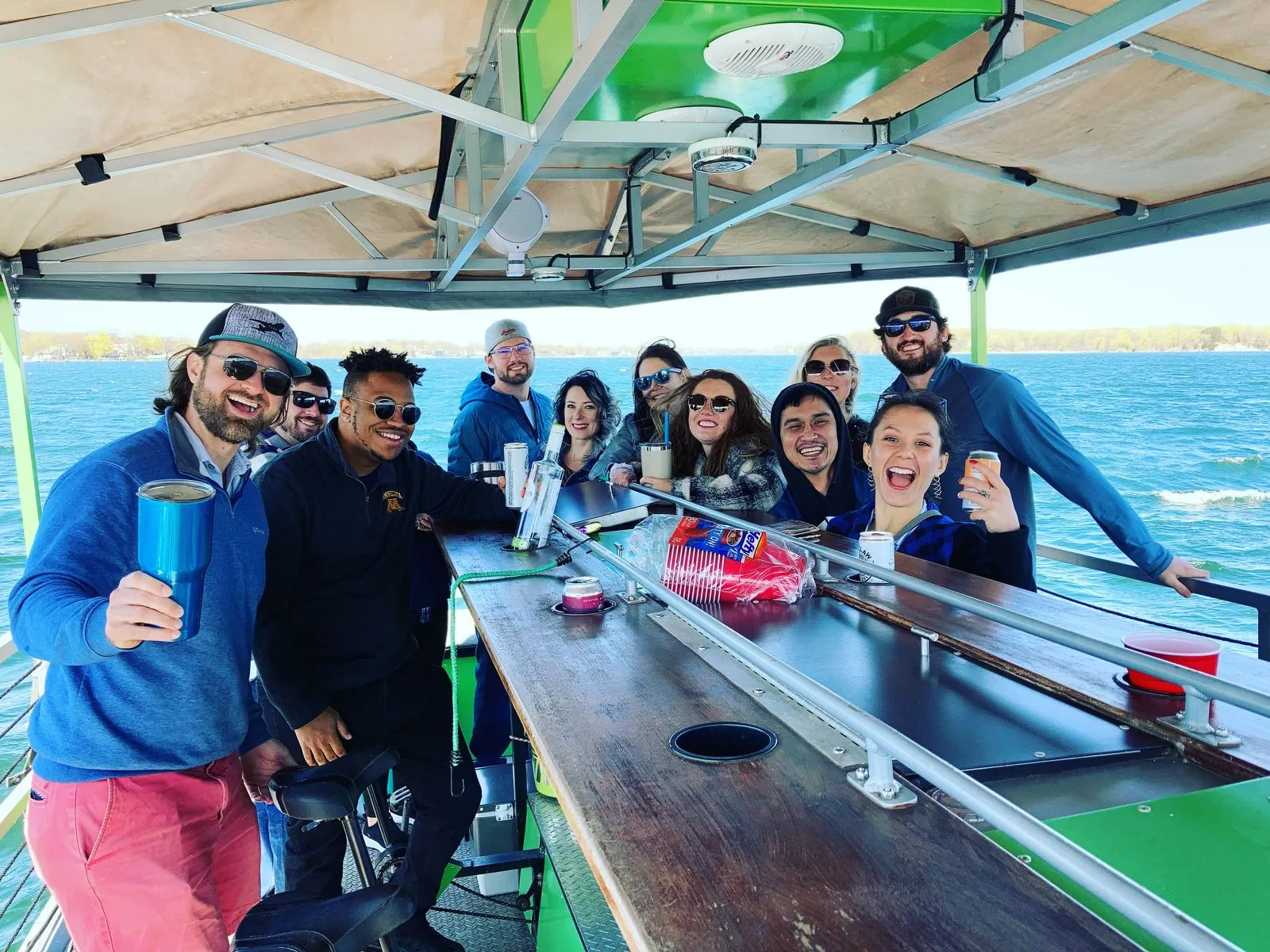 A group of friends raising their drinks on a PaddleTap boat