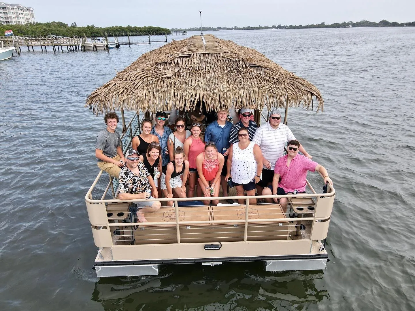 A big group of friends on a PaddleTap tiki boat on the lake